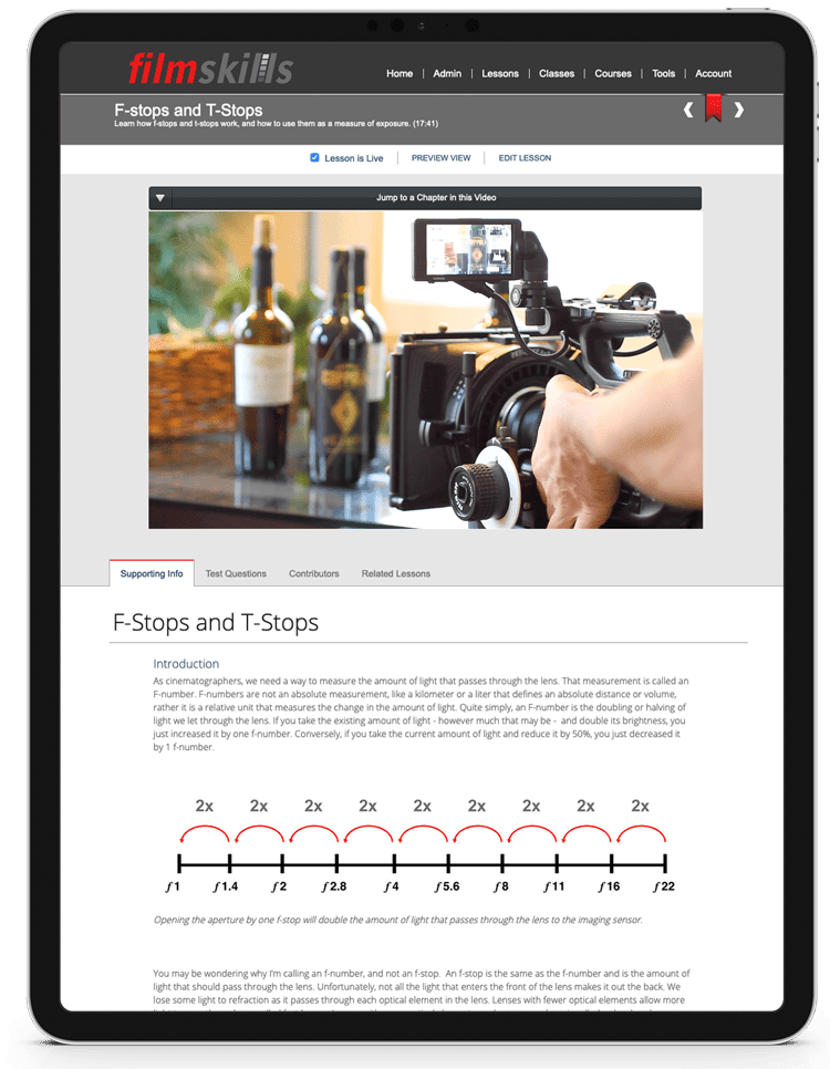 An iPad displays a FilmSkills Academic lesson about F-stops and T-stops. At the top is an image of a camera shooting wine bottles. Below is a text article about f-stops and t-stops.